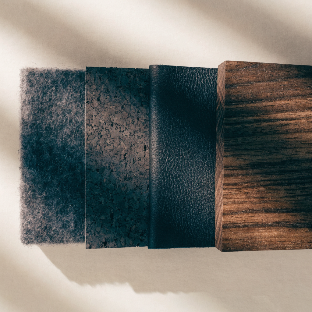 Swatches of wool felt, cork, black leather and oiled walnut laid in a row