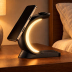 Black Charge Arc on a bedside table holding a phone with its warm light on.